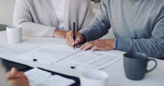 couple signing a document at an office